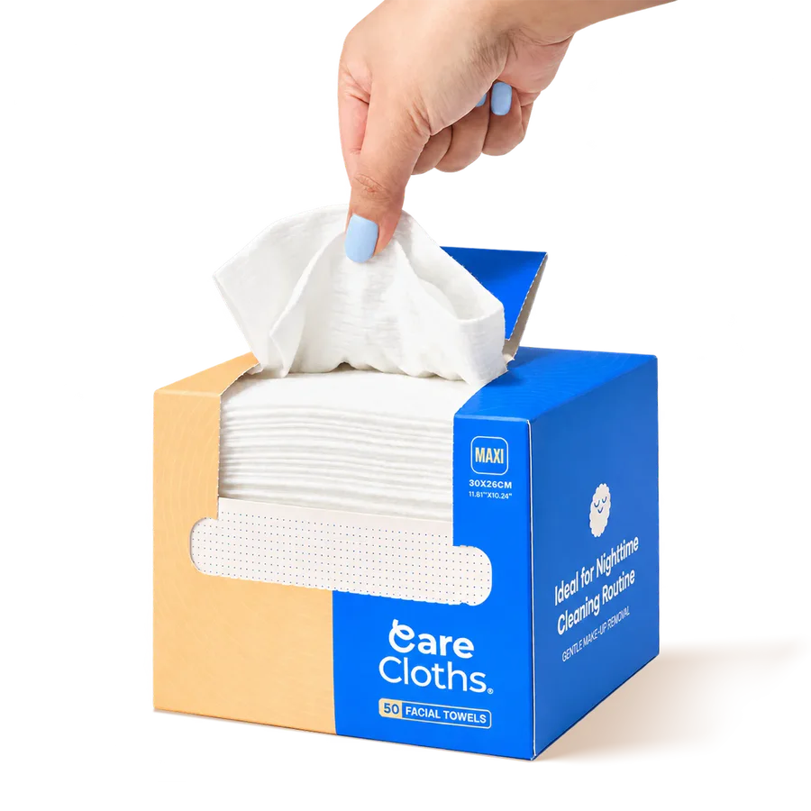 Open CareCloths MAXI box showing the stack of 50 facial towels, a hand pulling one out
